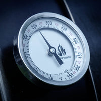 A Tel Tru offset smoker thermometer with custom 'Smoke North' logo shown with the dial indicating a temperature of 250 degrees